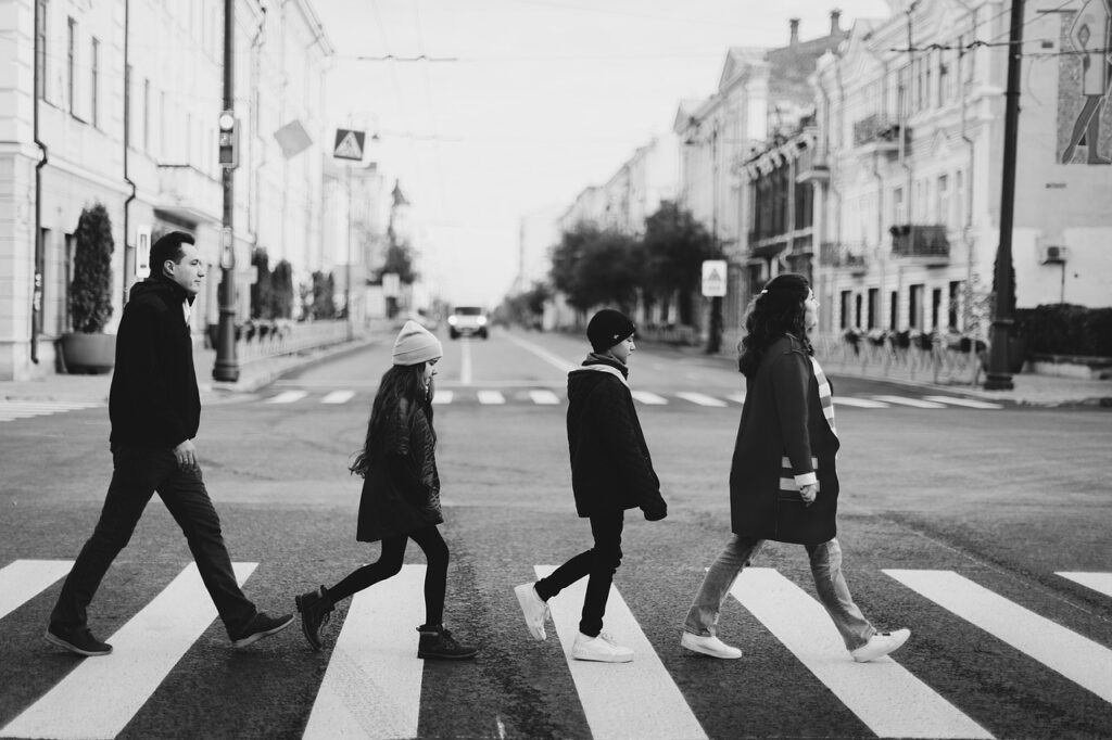 black and white shot of a family walking crossing a street